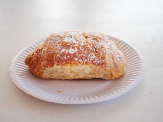 Plain croissant on a white paper plate , Selective focus, One.