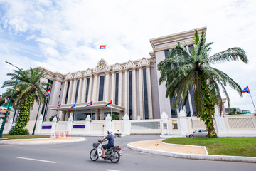 Khmer people riding motorcycle pass the Royal Government Hall of Cambodia.