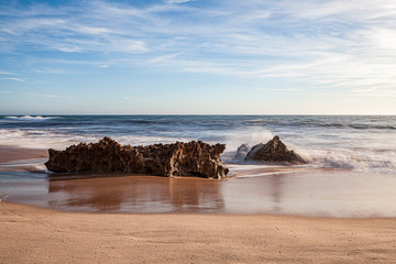 Fototapeta premium Rochas na rebentação das ondas, no areal da praia, na “Praia da Ilha” em Porto Covo (Costa Vicentina), Alentejo, Portugal, Europa.