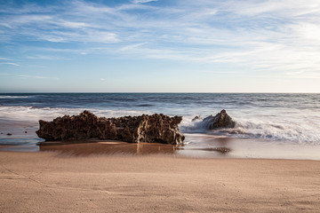 Rochas na rebentação das ondas, no areal da praia, na “Praia da Ilha” em Porto Covo (Costa Vicentina), Alentejo, Portugal, Europa.
