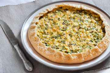 Tart with eggs and green onions on a plate