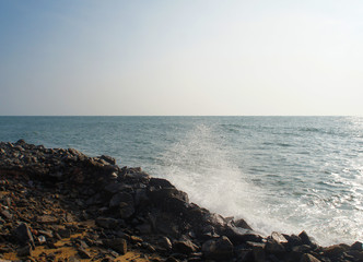 Waves seethe and hit the stone beach on the tropical island of Sri Lanka in the summer.