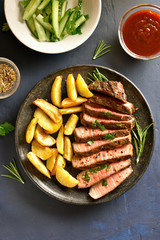 Medium rare roast beef with potato wedges