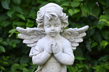 A white sandstone sculpture of a praying angel.