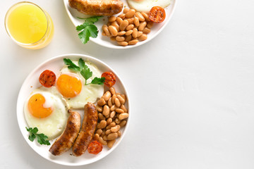 Fried eggs, sausages, beans, tomatoes, greens