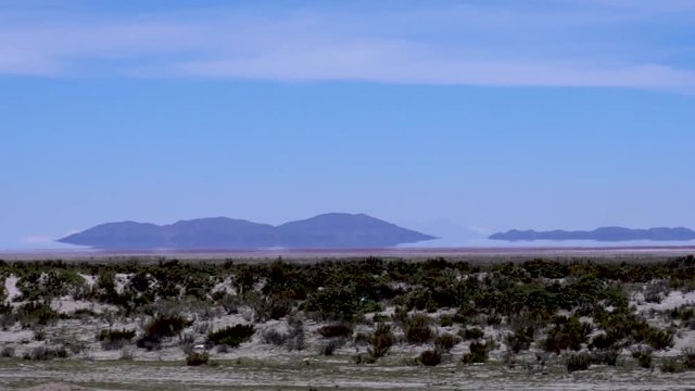 Desert with Mirage , fata morgana and Mountains in Horizon as seen from train, near Salar de Uyuni salt flats, Bolivia, South America, slow motion