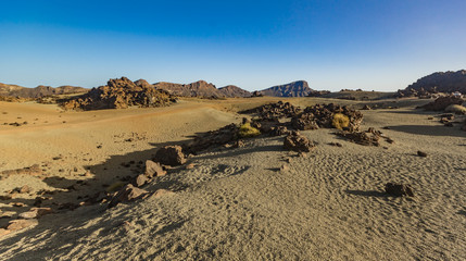 Fototapeta na wymiar Volcanic landscape of Tenerife with dry lava rocks in foreground. Canary Islands, Spain. Teide National Park.