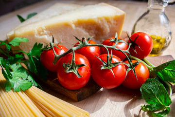 Healthy vegan food lunch. Vegetarian dining table. Tomatoes, spaghetti, cheese, vegetables on the background.