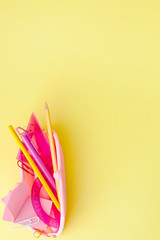 Back to school concept with space for text. Top view. Copy space. School office supplies.Creative desk with colourful stationery. Colored paper clip.School supplies on yellow background.Office desk