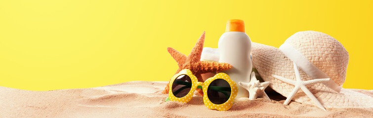 Sunblock Bottle with summer accessories on solid background