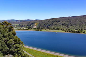 Fototapeta na wymiar Clear blue reservoir set in the hills in North Island, New Zealand