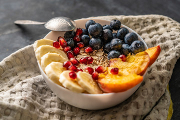 morning healthy breakfast, cereal with exotic fruits, blueberry, banana, garnet and pears