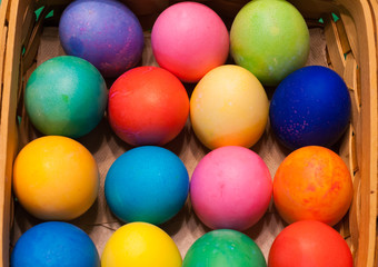 Fototapeta na wymiar Looking down on a basket of multi-colored easter eggs