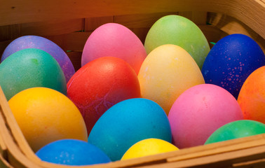 Fototapeta na wymiar Side view of a wooden basket of multi-colored easter eggs