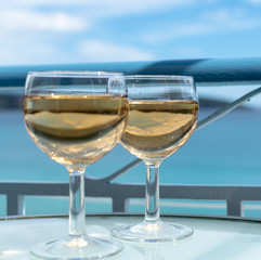 White wine served outside on balcony on glass table with sea view