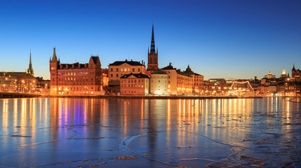 Riddarholmen - part of the historical Old Town (Gamla Stan) in Stockholm, Sweden, at dawn, before sunrise, in winter, surrounded by ice.