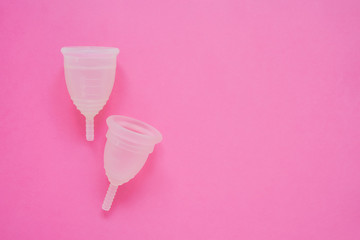 Two Menstrual cup on pink background. Alternative feminine hygiene product during the period. Women health concept. Copy space