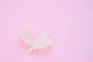 Two Menstrual cup on pink background. Alternative feminine hygiene product during the period. Women health concept. Copy space