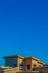 Exterior of a house under construction against vast blue sky on a sunny day
