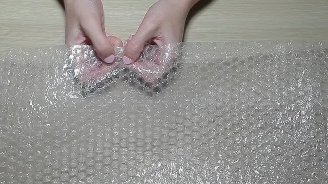 bubble pack woman hand table hd footage 