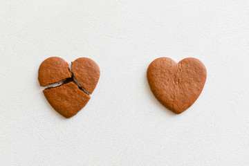 Heart-shaped cookies, one of them is broken on a white background. Breaking cookies is the concept...