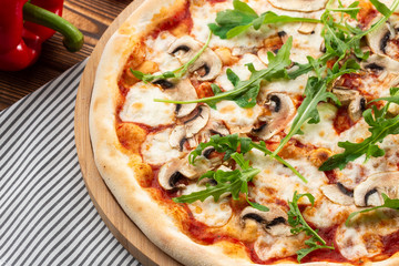 Italian Delicious Fresh Hot Mix Baked Pizza with Melting Cheese, sliced mushrooms , tomato sauce and cheddar serving on textured rustic background. Mushrooms pizza. top view.