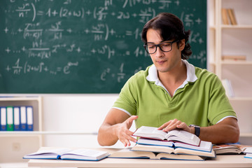 Handsome student in front of chalkboard with formulas 