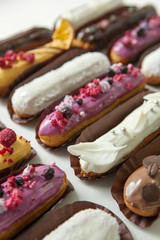 Set of several eclairs with various fillings and design isolate on a white background, the concept of French cuisine