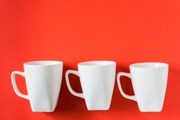3 white winter coffee cup mugs lined up in a row for a break time meeting; Copyspace with empty...