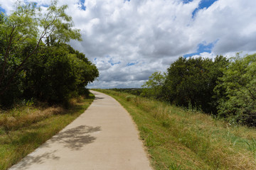 Concrete path in the city park on a sunny June day