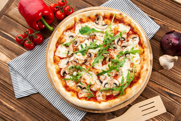 Italian Delicious Fresh Hot Mix Baked Pizza with Melting Cheese, sliced mushrooms , tomato sauce and cheddar serving on textured rustic background. Mushrooms pizza. top view.