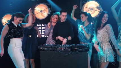 Young women dancing and flirting with the dj in a night club