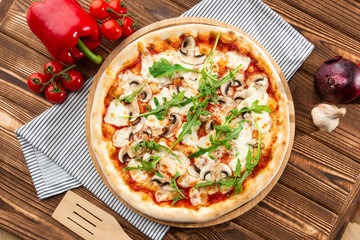 Italian Delicious Fresh Hot Mix Baked Pizza with Melting Cheese, sliced mushrooms , tomato sauce and cheddar serving on textured rustic background. Mushrooms pizza. top view.