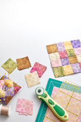 Bright square pieces of fabric, quilting tools, sewing equipment, traditional patchwork, space for text