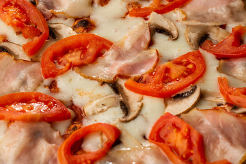 Italian Delicious Fresh Hot Mix Baked Pizza with Melting Cheese, sliced mushrooms , ham, tomato sauce and cheddar serving on textured rustic background. top view.