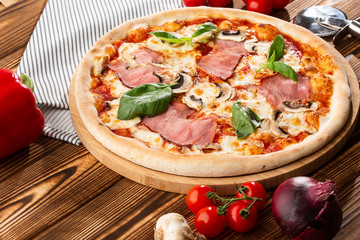 Italian Delicious Fresh Hot Mix Baked Pizza with Melting Cheese, sliced mushrooms , ham, tomato sauce and cheddar serving on textured rustic background. top view.
