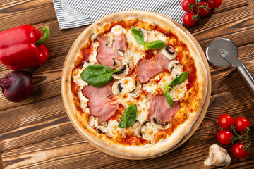 Italian Delicious Fresh Hot Mix Baked Pizza with Melting Cheese, sliced mushrooms , ham, tomato sauce and cheddar serving on textured rustic background. top view.