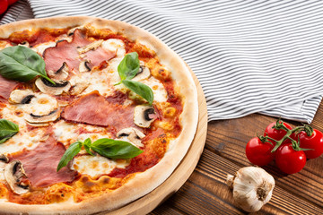 Italian Delicious Fresh Hot Mix Baked Pizza with Melting Cheese, sliced mushrooms , ham, tomato sauce and cheddar serving on textured rustic background. top view.