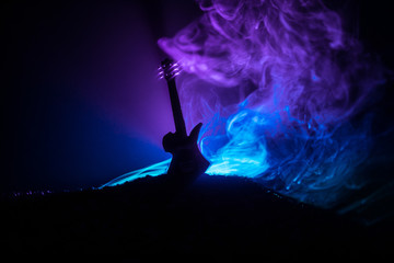 Music concept. Acoustic guitar isolated on a dark background under beam of light with smoke with...