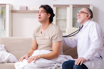 Obraz premium Old male doctor visiting young male patient 