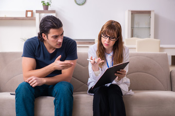 Young male patient discussing with female psychologist personal 