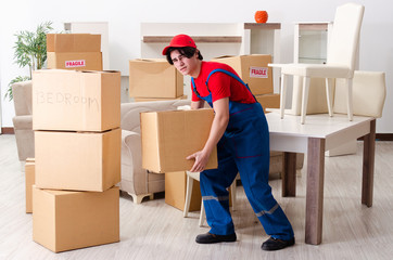 Young male contractor with boxes working indoors 