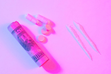 Twisted banknote through which sniffing cocaine. A hundred dollars bills and a lot cocaine scattered on the table. Illegal drugs and dirty money. Neon rawe style. Breaking the law, drug addiction.
