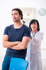 Young male patient visiting aged female doctor 