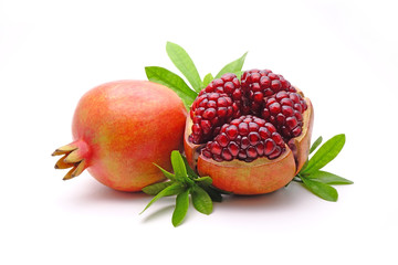 Pomegranate whole and cut with green leaves isolated on white background. Pomegranates (Punica granatum) is a fruit-bearing deciduous shrub in the family Lythraceae. Pomegranate fresh fruit Isolated.