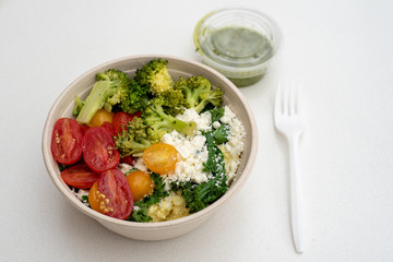 Mediterranean meal on white bowl on white table with basil sauce- healthy fast food concept