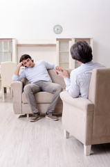 Young male patient discussing with psychologist personal problem