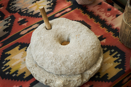 The ancient quern stone hand mill with grain, close-up