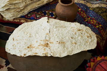 Pita bread baking on a saj or tava on fire, close-up