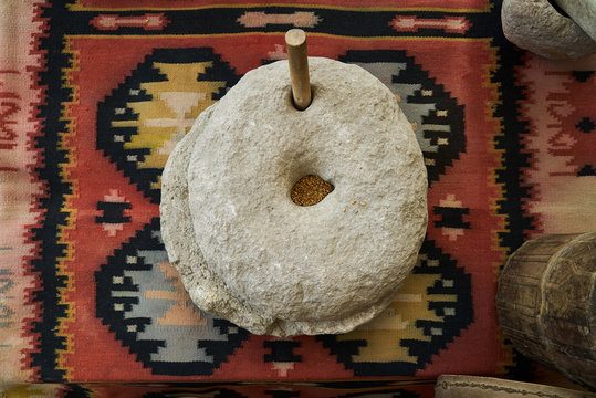 The ancient quern stone hand mill with grain, close-up
